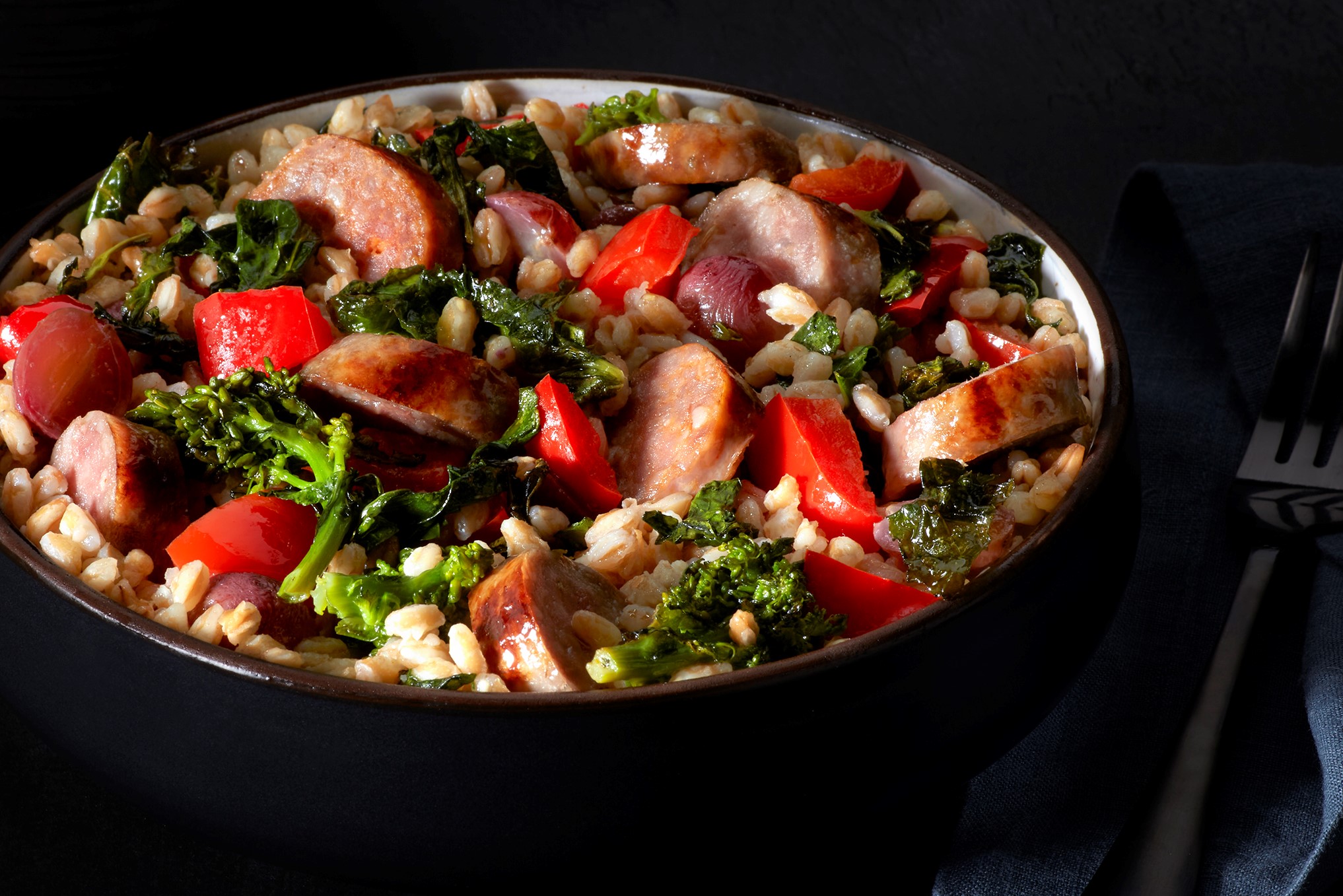 Italian Sausage combined with farro, roasted red pepper, grapes and broccoli rabe for a light and healthy lunch or dinner.